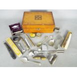 A wooden box containing a quantity of collectables including cut throat razors, napkin rings,