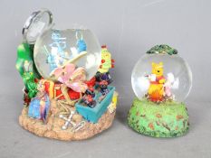 Two Disney musical snow globes comprising 'A Bug's Life' and Winnie The Pooh,