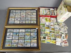 A collection of cigarette and tea cards with some framed examples.