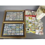 A collection of cigarette and tea cards with some framed examples.