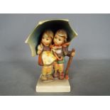 Hummel - A large Hummel figural group depicting two children standing under an umbrella,