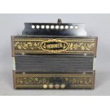 A Hohner ten button accordion in gilt decorated ebonised case, made in Germany,