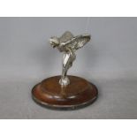 A Flying Lady car mascot on wooden base,