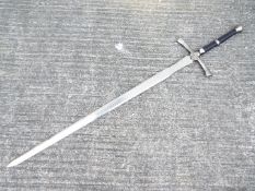 A replica two-handed broad sword with metal pommel and cross-guard, faux leather handle,