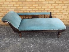 An upholstered chaise longue on turned supports having castors,