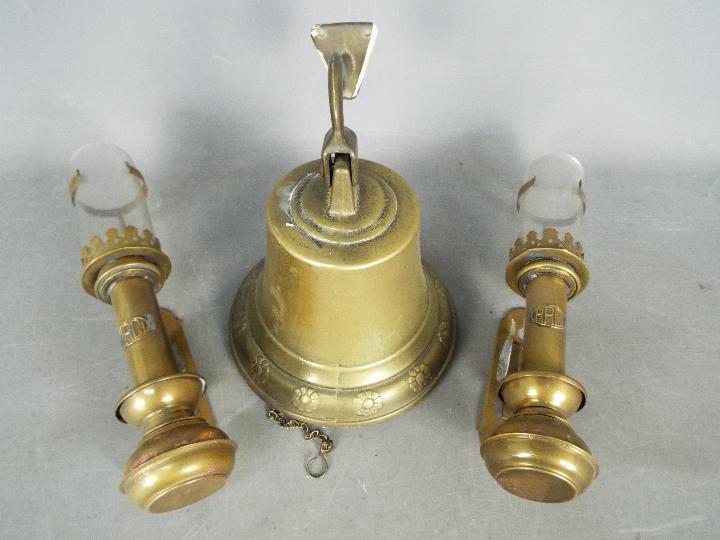 A wall mountable brass bell and two railway carriage lanterns.