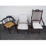 A folding chair and an armchair with white upholstery along with an ebonised corner chair having