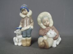 Lladro - Two Lladro figurines comprising # 5238 'Eskimo Boy With Pet' and # 1195 'Eskimo Playing',