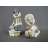 Lladro - Two Lladro figurines comprising # 5238 'Eskimo Boy With Pet' and # 1195 'Eskimo Playing',