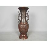 A large bronze vase with relief decoration of birds and flowers, twin dragon handles to the neck,