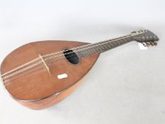 An early 20th century eight-string mandolin, unsigned, 59 cm length,