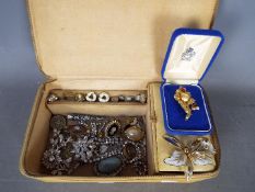 A jewellery box containing a quantity of brooches, rings, earrings,