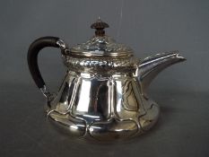 An Edward VII, Art Nouveau, hallmarked silver teapot with sinuous floral repousse decoration,