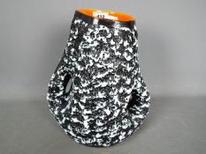 A Vallauris studio pottery twin handled vase with black and white textured exterior and orange lava