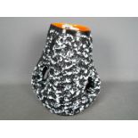 A Vallauris studio pottery twin handled vase with black and white textured exterior and orange lava