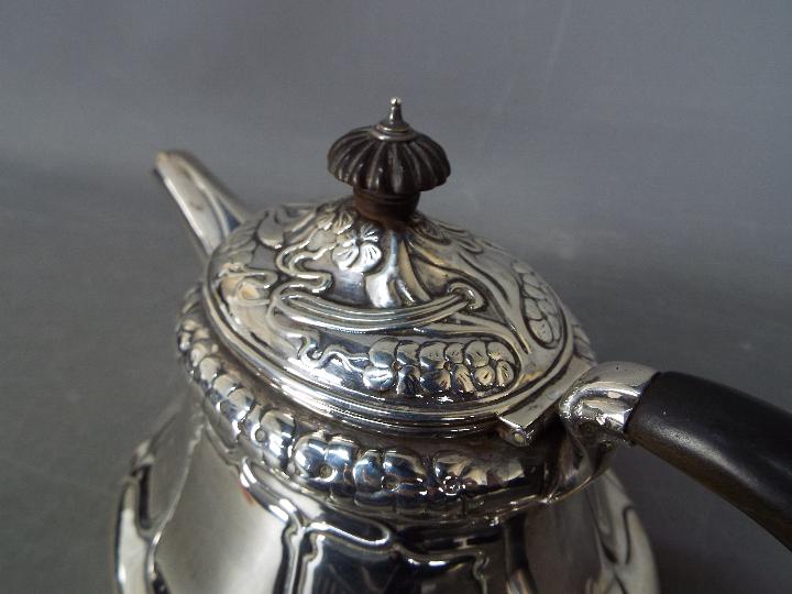 An Edward VII, Art Nouveau, hallmarked silver teapot with sinuous floral repousse decoration, - Image 3 of 6
