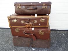 Three vintage suitcases and a wooden case.