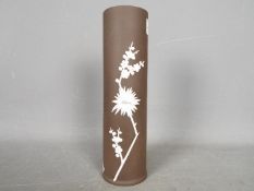 A brown Wedgwood Jasperware vase decorated with flowering prunus, impressed marks to the base,