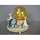 A Disney musical snow globe featuring Winnie The Pooh characters, approximately 18 cm (h).