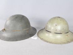 Two World War Two period Zuckerman pattern steel helmets, one marked AMC for Austin Motors Company,