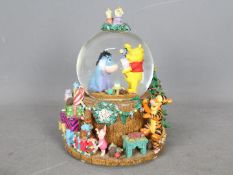 A Disney musical snow globe, Winnie The Pooh, approximately 21 cm (h).