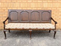 A good quality settle with upholstered seat, approximately 99 cm x 182 cm x 72 cm.