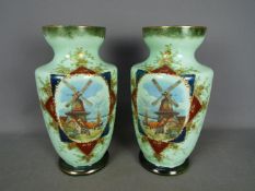 A large pair of continental glass vases decorated with a coastal village scene with windmill and a