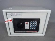 A Home Protector digital electronic safe, approximately 25 cm x 35 cm x 26 cm,