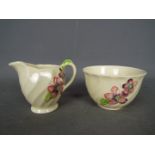 Clarice Cliff for Royal Staffordshire, a sugar bowl and cream jug with floral decoration,