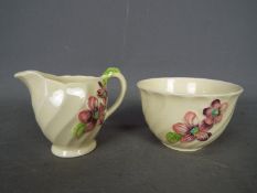 Clarice Cliff for Royal Staffordshire, a sugar bowl and cream jug with floral decoration,