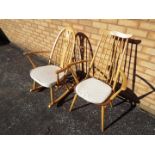 An Ercol rocking chair with carved swan motif to backrest and an Ercol stickback armchair.