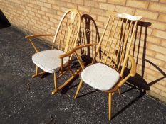 An Ercol rocking chair with carved swan motif to backrest and an Ercol stickback armchair.