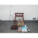 An artist's easel and a large quantity of paints and accessories.