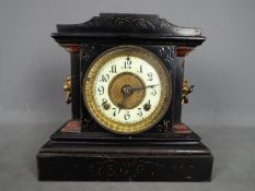 A late 19th century Ansonia Clock Company, black painted, cast iron mantel clock,