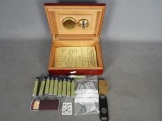 A vintage Dupont cigarette lighter with a quantity of accessories and a cigar humidor.