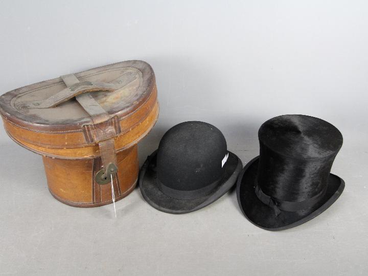 A leather top hat box containing a T Crick, Bury top hat,