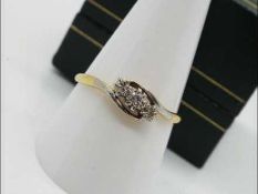 An 18ct gold and platinum crossover ring set with three old cut diamonds approx 20pts,