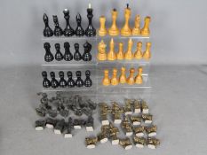 Two chess sets, a carved wooden example with 12 cm king and a cast metal set with 10 cm king.