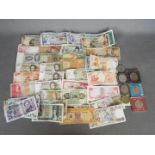 A collection of world banknotes and some commemorative crowns.