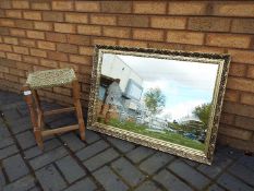 A wall mirror decorated with horse and carriage, approximately 60 cm x 86 cm and a small stool.