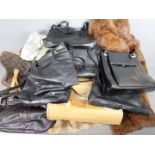 A collection of handbags and two fur coats.