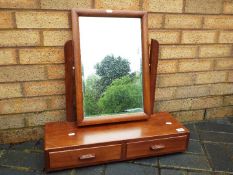 A table top swing mirror over two drawers.