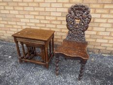 A nest of three tables and a highly carved hall chair.