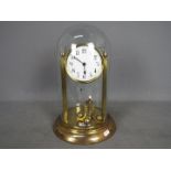An early 20th century 400-day torsion clock, large 11cm enamel dial, mounted between reeded pillars,