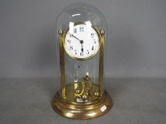 An early 20th century 400-day torsion clock, large 11cm enamel dial, mounted between reeded pillars,