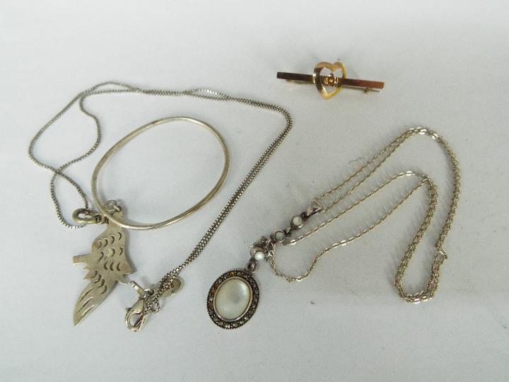 Two Silver necklaces and a heart brooch,