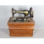 An antique Singer sewing machine in case, serial number 14677197.