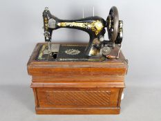 An antique Singer sewing machine in case, serial number 14677197.