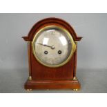 A French arch top mantel clock, Arabic numerals to a white metal, engine turned dial, with key,