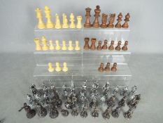 Two chess sets comprising a carved wooden set, 8.5 cm king and a cast metal set with 9 cm king.